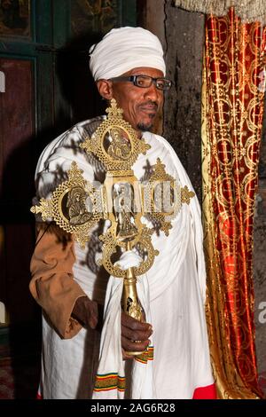 L'Éthiopie, l'Amhara, Lalibela, Mont Abouna Yosef, à l'intérieur, Asheton Maryam Monastère, prêtre tenant les grandes croix de bronze Banque D'Images