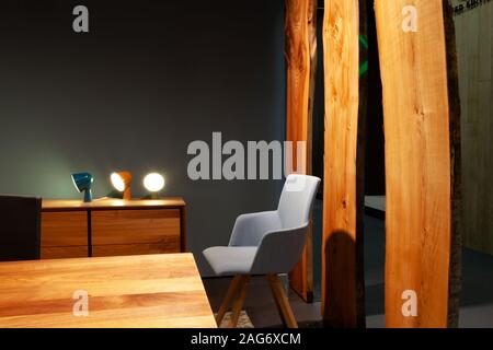 Fauteuil à côté d'une table en bois dans la salle de séjour dans la soirée de l'intérieur Banque D'Images