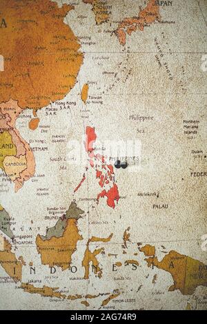 Photo verticale d'une épingle noire sur le pays des Philippines sur la carte Banque D'Images