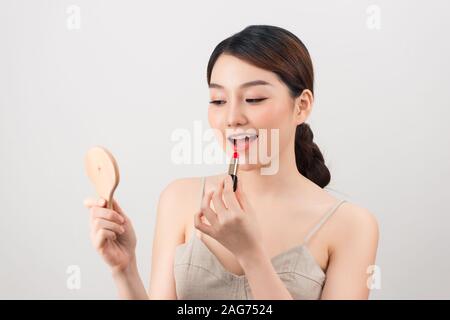 Fille de rouge à lèvres avec miroir et Banque D'Images