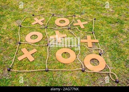 Tic Tac Toe jeu de cordes et de bois placée sur l'herbe - libre Banque D'Images