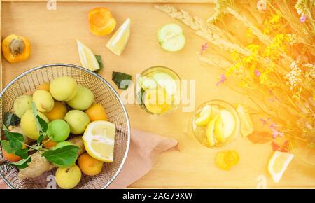 L'été avec de la limonade citron, citron vert, gingembre menthe, de fleurs sauvages, d'abricot sur la table. Boissons de refroidissement Banque D'Images