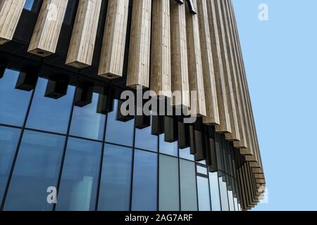 Photo d'un bâtiment moderne en verre recouvert d'un petit angle un rideau de pierre sous le ciel clair Banque D'Images