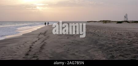 Un couple bénéficiant d'un coucher du soleil à pied sur une plage isolée au Cap Vert Banque D'Images