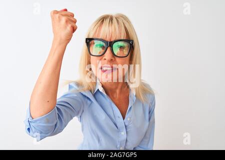 Femme d'âge moyen portant des lunettes de soleil et sa chemise sur fond blanc isolé contrarié et frustré de crier avec colère, fou et hurlements wit Banque D'Images