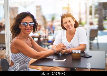 Belle Mère et fille assis à une terrasse de restaurant parlant et souriant Banque D'Images