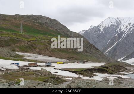 Camions se rendant sur l'étroite Srinagar - Leh National Highway entouré de neige dans Les Drs, Ladakh. L'autoroute n'est ouverte qu'en été. Banque D'Images