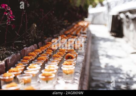 Photo sélective de fleurs d'orange dans des verres en plastique avec un arrière-plan flou Banque D'Images