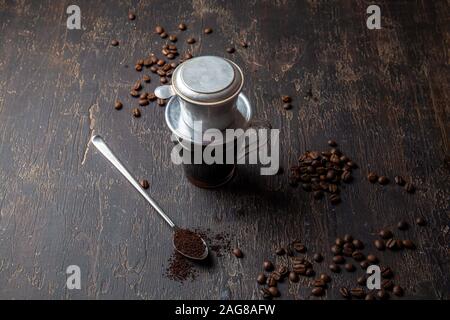 Préparation du café vietnamien avec l'aluminium cofe filer sur fond sombre Banque D'Images