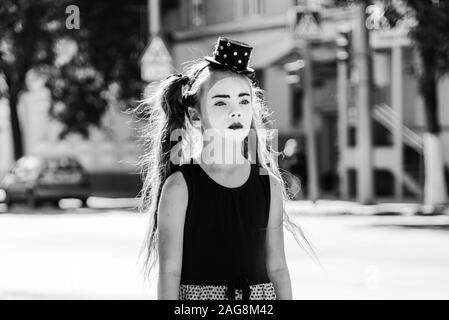 Triste petite fille mime debout sur la route dans la ville Banque D'Images