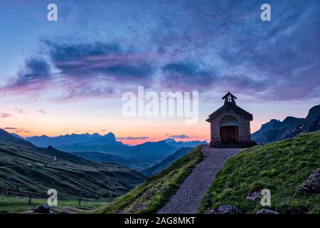 Une petite chapelle près de Pordoi Passo Pordoi pass, au lever du soleil, le Setsas montagnes au loin Banque D'Images