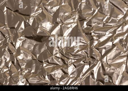 La texture du papier aluminium froissé cuisine d'or. Résumé en blanc pour la conception. Banque D'Images