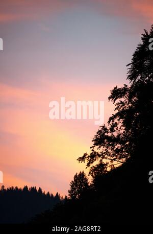 Un magnifique coucher de soleil rouge foncé avec forêt de pins et montagnes dans les Alpes françaises près de Montriond Portes du Soleil France Banque D'Images