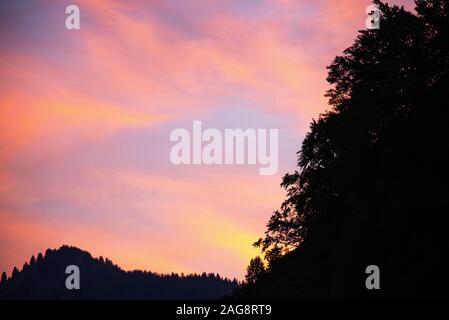 Un magnifique coucher de soleil rouge foncé avec forêt de pins et montagnes dans les Alpes françaises près de Montriond Portes du Soleil France Banque D'Images