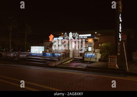 Jeju, Corée du Sud, 09 septembre 2019 : avis de coréen typique restaurant de fruits de mer avec des panneaux lumineux et des décorations dans la nuit Banque D'Images