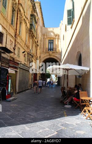 La Valette, Malte - 13 septembre 2016 : scène de rue avec les touristes à flâner dans les rues médiévales étroites de La Valette, Malte. Banque D'Images