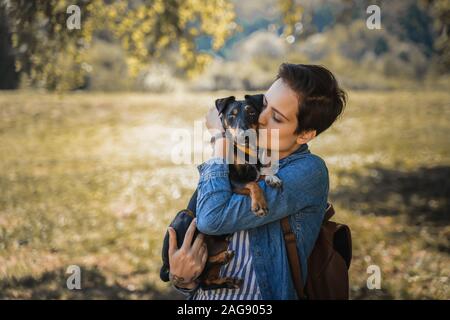 Un joli portrait comment une fille l'embrasse chien comme son meilleur ami dans un champ Banque D'Images