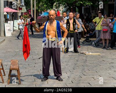 HAINAN, CHINE - 3 mar 2019 - un artiste martial chinois asiatique homme exécute avec une épée en costume traditionnel au Feng Xiaogang movie town, Hainan. Banque D'Images