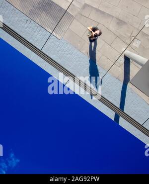 L'angle inhabituel selfies photo - photographe visant directement l'appareil photo vers le haut dans un miroir, toit sombre ciel bleu en bas Banque D'Images