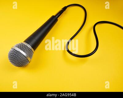 Microphone avec câble bouclés sur fond jaune Banque D'Images