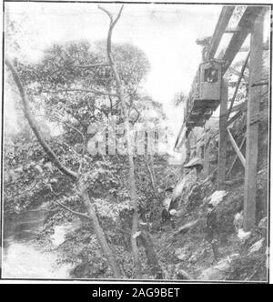 . Scientific American Volume 92 Numéro 11 (mars 1905). Des fondations en béton pour les supports du pont en fer qui enjambe la rivière.Telpher avec pleine charge à propos de passer autour de la courbe. À partir de l'entrepôt, le Telpher train traverse la route, Arrondit la courbe, voyages le long de la berge de la rivière, puis traverse la rivière sur un pont en fer et entre dans l'usine.. Banque D'Images