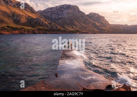 Jetée de pierre/pier El Calo près de Betlem et Colonia de Sant Pere, de vertes collines avec belle lumière, l'après-midi avec ciel bleu et nuages blancs, Mallorca, S Banque D'Images