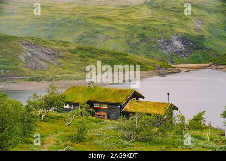 En bois norvégienne maison d'été donnant sur le lac pittoresque, Norvège, Scandinavie. Chalet au bord du lac en milieu rural. Cabane au toit de tourbe sur le lac. Au toit d'herbe typique Banque D'Images