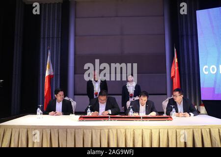 (191218), Manille, 18 décembre 2019 (Xinhua) -- Junn Magno (2L, à l'avant), directeur général de Philippine National Railways (DP), et Wang Qiaolin (2e R, à l'avant), sous-directeur général de la Chine Le matériel roulant ferroviaire Corporation (CCRR) Zhuzhou Locomotive Co., Ltd., signer le contrat sur l'achat de trains à Manille, Philippines, le 18 décembre 2019. La Chine et les Philippines ont signé un accord sur l'achat de trains sur mercredi, comme les Philippines vont importer des trains fabriqués en Chine pour la première fois. Selon le contrat signé par la Chine de matériel roulant bouilloire CRRC Zhuzhou Locomotive C Banque D'Images