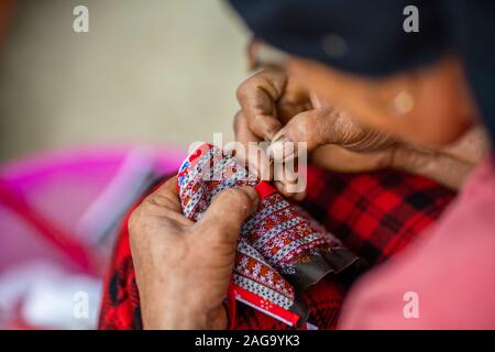 Prise de vue en grand angle d'une femme d'âge moyen avec les mains endommagées Fabrication de vêtements vietnamiens traditionnels Banque D'Images