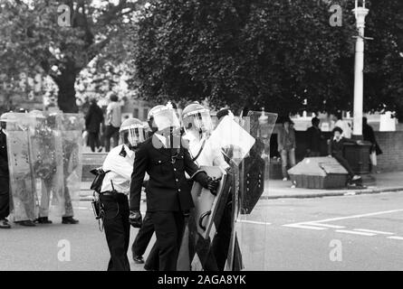 Un policier noir (deuxième à gauche) avec des collègues casqué porter boucliers antiémeutes près de Lambeth de ville à Brixton, Londres, après qu'ils ont essayé de réprimer les émeutes dans la région. Banque D'Images