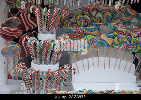 Gros plan d'un groupe de petites et grandes sucettes rondes colorées dans la cellophane. Des sucettes colorées sur le marché libre. Banque D'Images