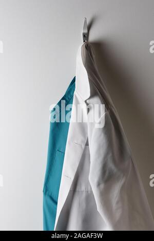 Les médecins d'un sarrau blanc et vert des gommages corporels suspendu à un crochet. Banque D'Images