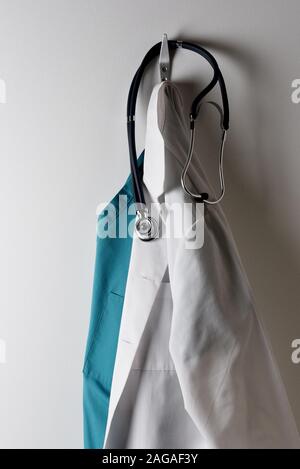Les médecins d'un sarrau blanc et vert des gommages corporels suspendu à un crochet avec stéthoscope. Banque D'Images