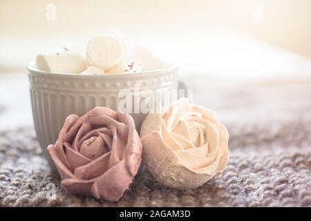 Réalisés à la main à partir de la compote avec des teintures naturelles de la guimauve en forme de roses. tasse de thé en arrière-plan rempli de lumière. Présent pour la femme sur la saint valentin Banque D'Images