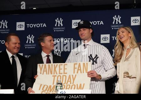 Bronx, United States. Dec 18, 2019. Scott Boras (L) et Hal Steinbrenner(2e à partir de L) regardent le Gerrit Cole est titulaire d'un signe de sa jeunesse avec Amy Cole comme les Yankees de New York organise une conférence de presse présentant leur nouveau 324 millions pitcher Gerrit Cole au Yankee Stadium de New York le Mercredi, Décembre 18, 2019. C'est le plus grand contrat jamais baseball en termes de valeur moyenne annuelle à 36 millions de dollars. Photo par Bryan Smith/UPI UPI : Crédit/Alamy Live News Banque D'Images