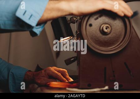 Homme tailleur faire un morceau de vêtement avec une couture machine en studio Banque D'Images