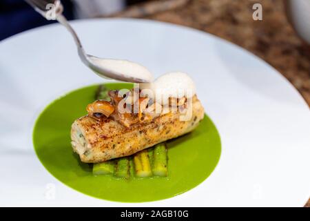 Gros plan de viande grillée et d'asperges frites dans un sauce végétarienne verte Banque D'Images