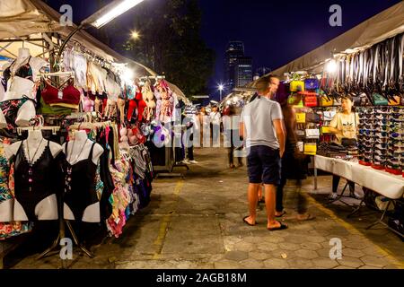 Les touristes à la recherche de vêtements à la cale au marché de nuit de Phnom Penh, Phnom Penh, Cambodge. Banque D'Images