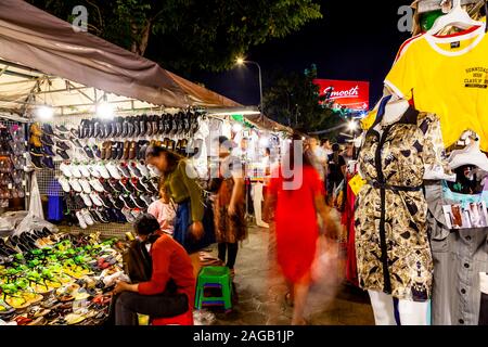 Les visiteurs à la recherche de vêtements à la Cale Le marché de nuit, Phnom Penh, Cambodge. Banque D'Images