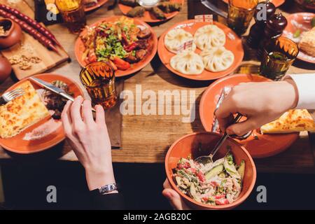 Vue de dessus de cuisine géorgienne sur table en bois brun.la nourriture traditionnelle géorgienne-khinkali chahokhbili,kharcho,,phali lobio,et les sauces - tkemal Banque D'Images