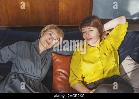 Les femmes d'âge moyen, souriant et discutant au repos Banque D'Images