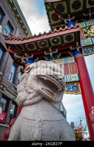 VICTORIA, CANADA - Nov 10, 2019 : Low angle shot de Chinatown Gates à Victoria, île de Vancouver BC montrant lion en pierre et portes colorées Banque D'Images