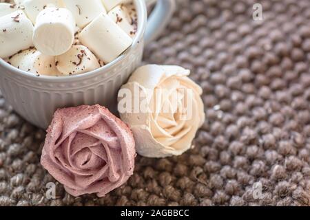 Marshmallow rose ressemble de près. tasse avec de petites guimauves saupoudrée de chocolat râpé sur tricoté coton serviette. Guimauve rose fait maison. Banque D'Images