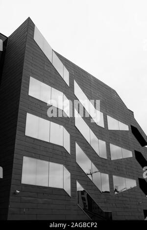 Plan vertical en échelle de gris d'un bâtiment moderne en béton avec réflexion fenêtres Banque D'Images