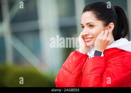 Fille de remise en forme. Jolie fille sportive d'exécution et l'écoute de la musique à l'extérieur. Style de vie sain dans la grande ville Banque D'Images