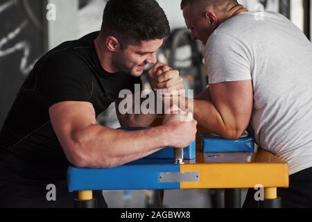 Comparaison de la force. Arm wrestling challenge entre deux hommes. Correspondance sur un tableau spécial Banque D'Images
