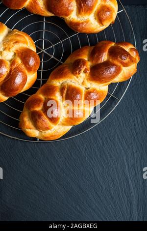 Concept cuisine maison pain frais braid challah ou pain brioché sur noir ardoise with copy space Banque D'Images