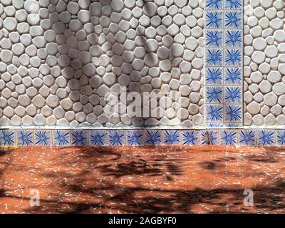 Détail du mur avec des cailloux et des carreaux de sol en céramique craquelée et Banque D'Images