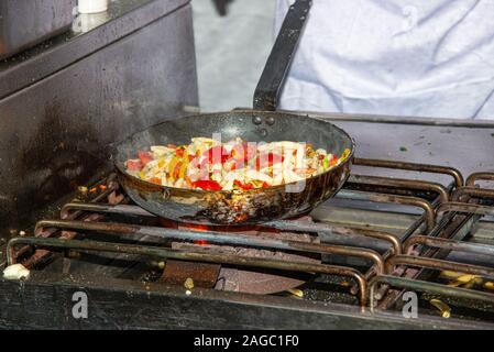 La cuisson des pâtes traditionnelles en santé repas avec légumes variété dans un steaminmg poêle chaude. L'alimentation saine cuisine française gastronomie concept Banque D'Images