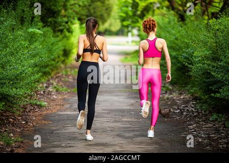 La remise en forme. Deux dames qui s'étend à l'extérieur dans les jambes en été Banque D'Images